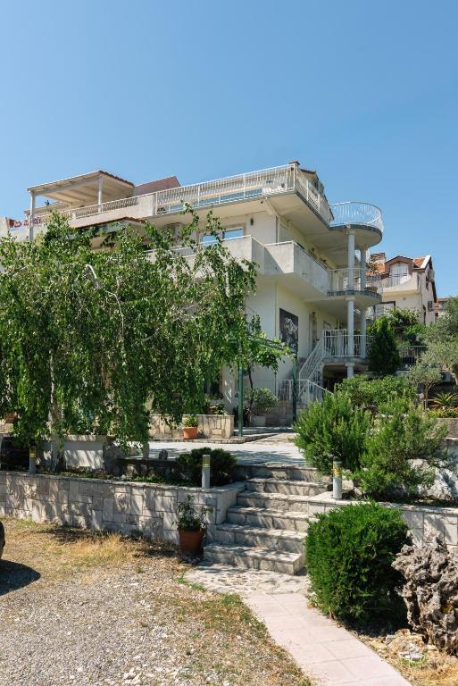 a house with stairs in front of it at Garden Apartments Lustica in Radovici