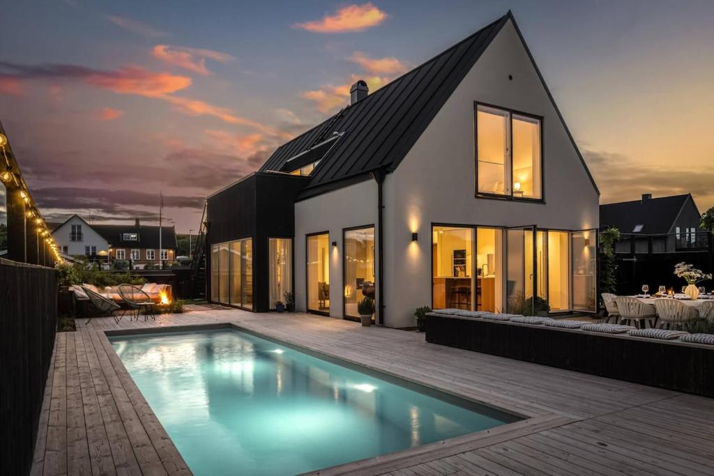 a house with a swimming pool in front of a house at Seaside villa with pool in Simrishamn