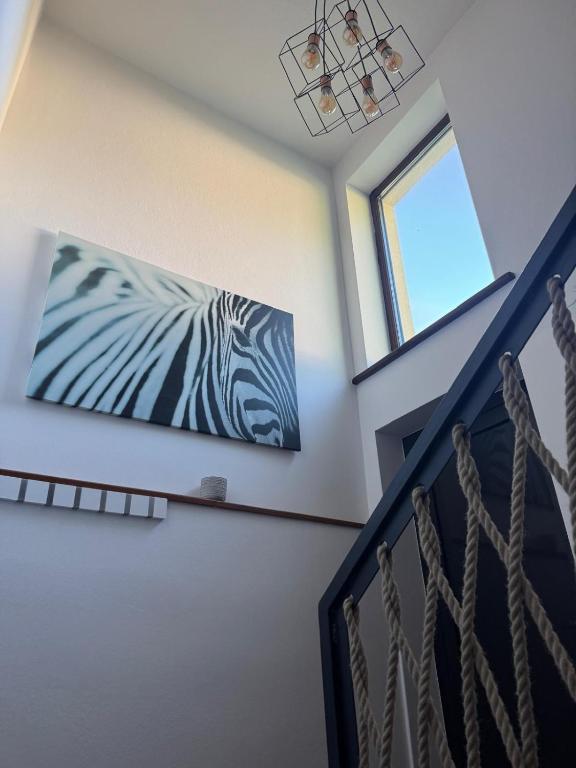 a painting of a zebra is hanging on a wall at Apartmán Lesný Dvor in Martinske Hole