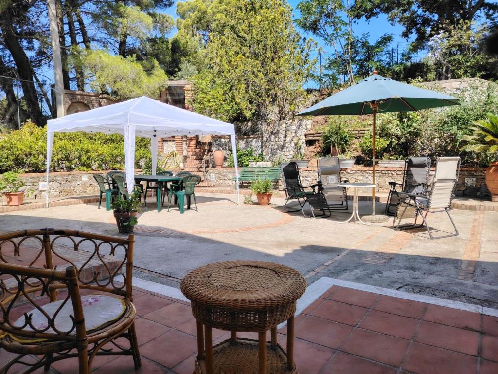 a patio with tables and chairs and an umbrella at La Casetta di Serenella in Andali