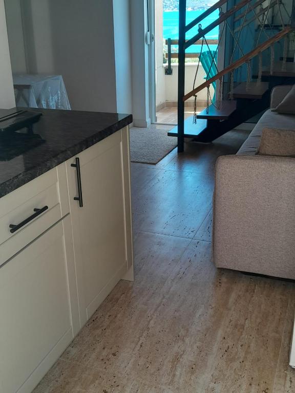 a kitchen with a counter top and a wooden floor at Apartman 4 sa spavacom in Zelenika