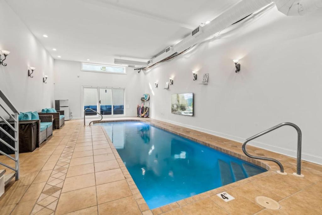 an indoor swimming pool with blue water in a house at 5 bdrm - Heated Indoor Pool - Roof Top Deck in Philadelphia