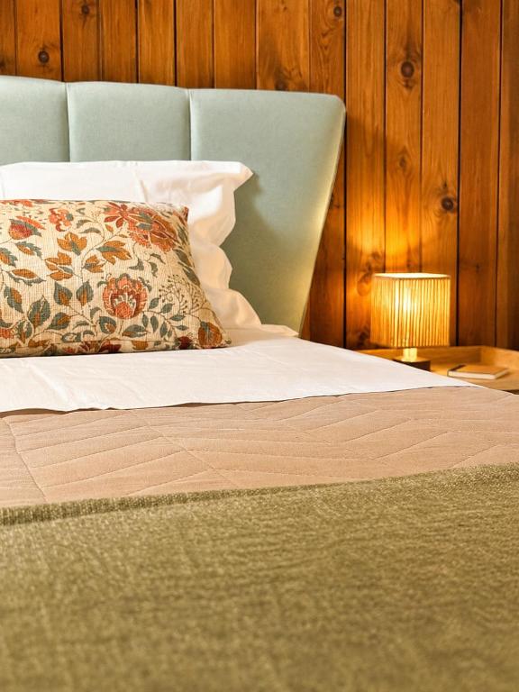 a bed with a pillow and a table with a lamp at Cà di Grè - Camigliatello Silano in Camigliatello Silano
