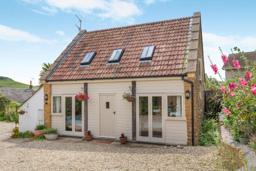 a small white cottage with a red roof at 2 Bed in Bridport oc-dc111 in Chideock