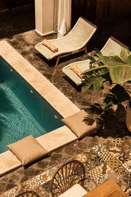 a swimming pool with lounge chairs and a table and a plant at Casa Lalla Hotel Rural in Douar Aguergour