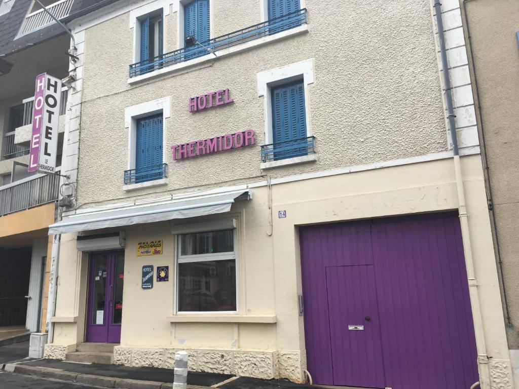 a building with a purple door on a street at Hôtel Thermidor in Nevers