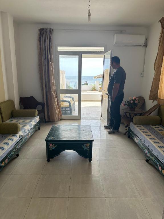 a man standing in a room with a table at Waterfront house 1 in Kelibia