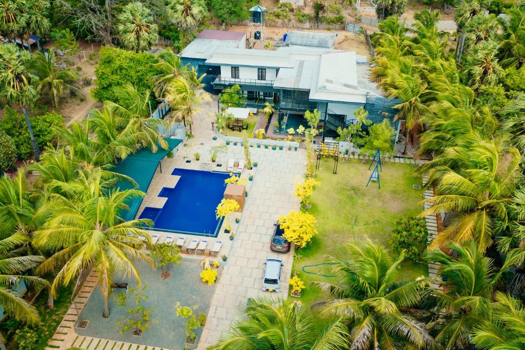an aerial view of a house with a swimming pool and palm trees at Aathi Resort in Trincomalee