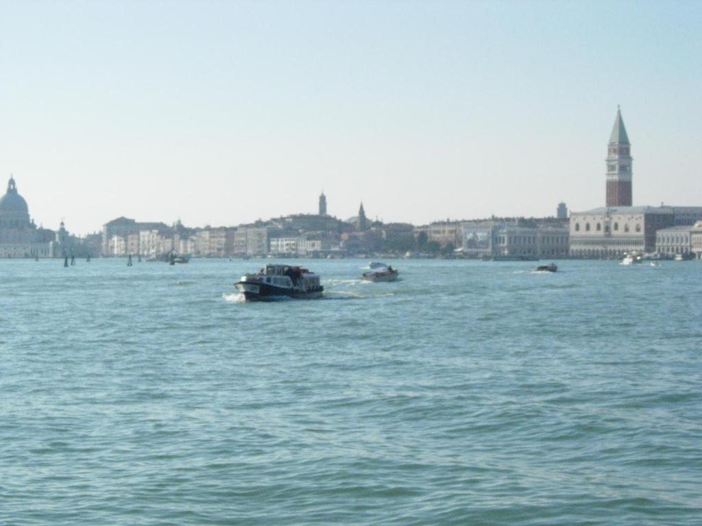 a boat in the water with a city in the background at Appartamento vacanzeCasadueottanta in Venice