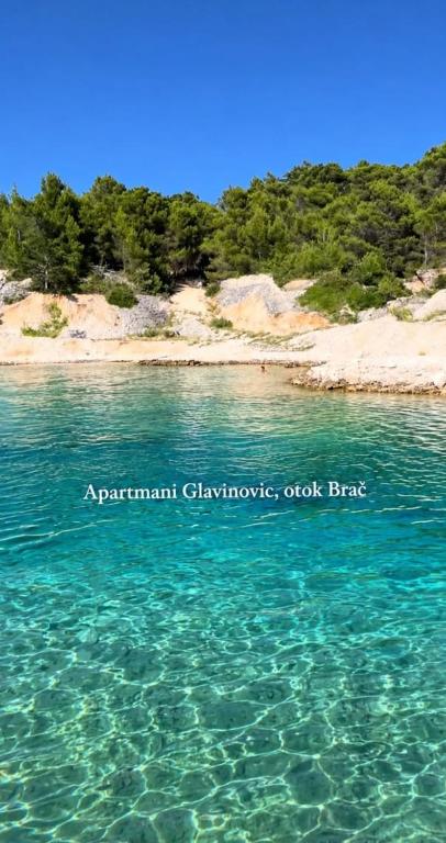 a body of water with a beach in the background at Apartments Glavinović - Near Beach and Center, Free Parking in Povlja