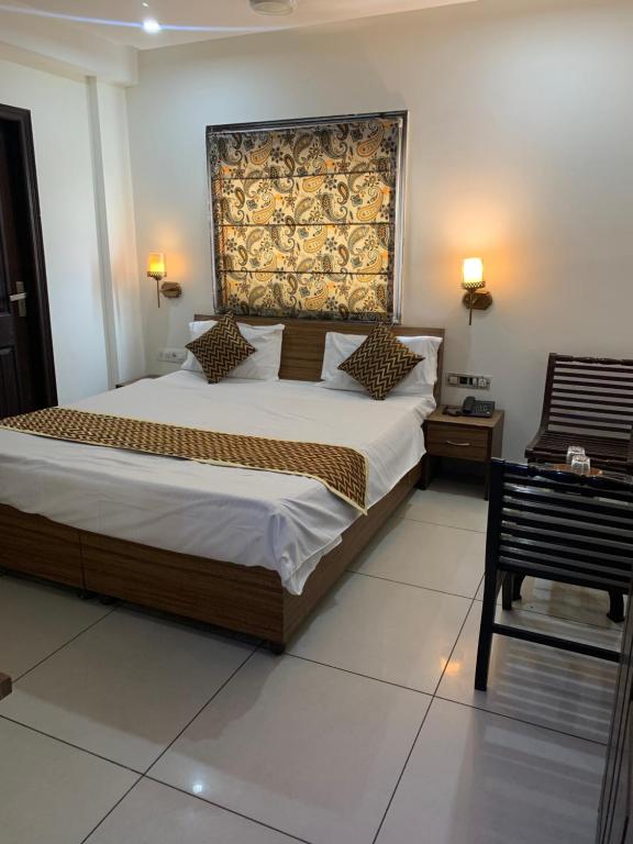 a bedroom with a large bed and a chair at narayana regency in Ludhiana