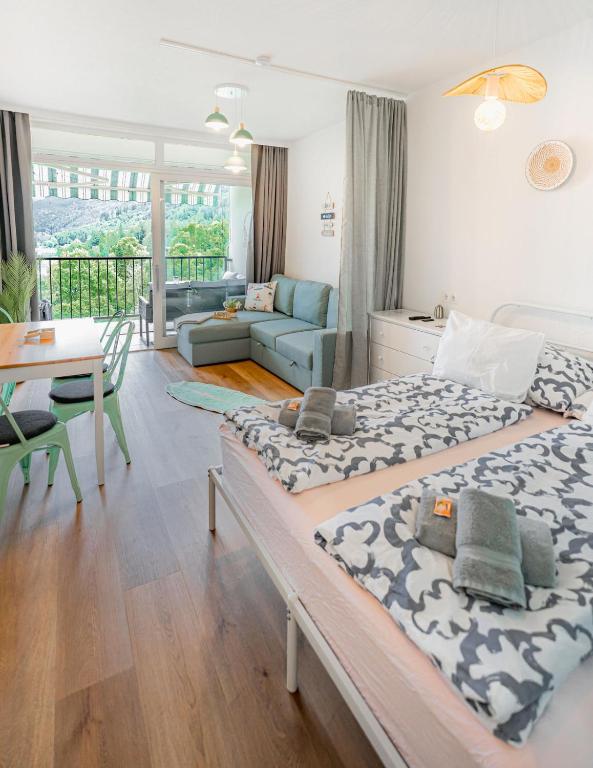 a bedroom with two beds and a living room at MOOKI Sky by Lake in Villach