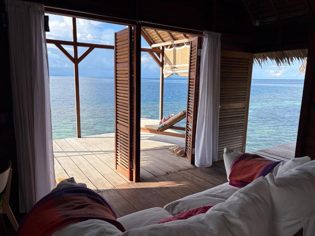 a room with a view of the ocean from a resort at ipyum Premium Overwater Guest House in Pulau Birie