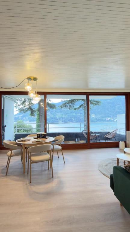 a living room with a table and chairs and a large window at Riflesso Apartment in Blevio