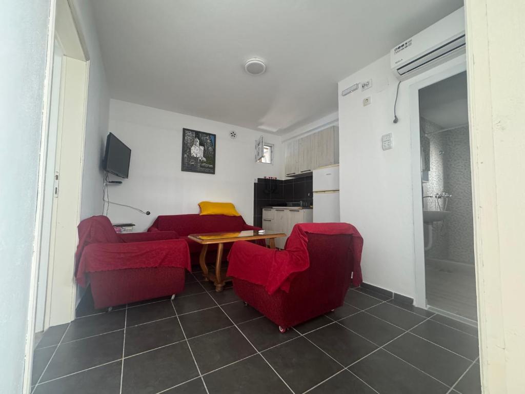 a living room with two red chairs and a table at Canj Cozy apartment 2 in Čanj