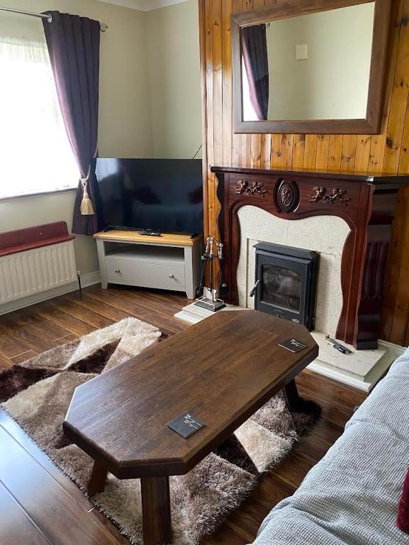 a living room with a table and a fireplace at Athenry Stay in Athenry