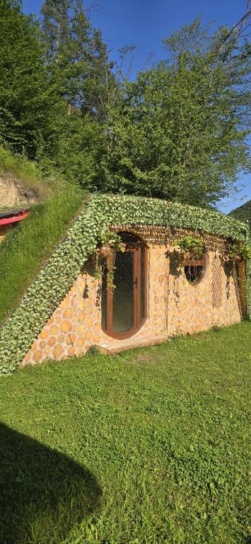 a stone building covered in ivy with a window at lazy trout house in Criva