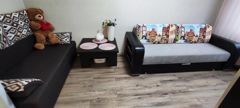a room with a couch and a bed and a teddy bear at Homestay Ezerkrasts in Liepāja
