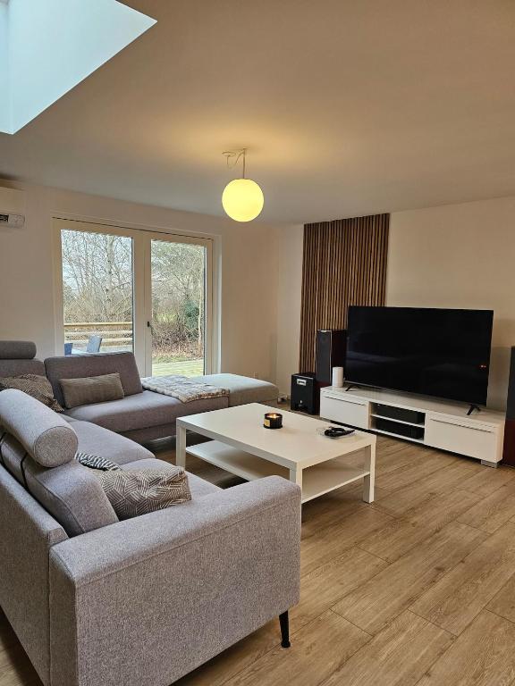 a living room with a couch and a flat screen tv at NordNest in Frederiksværk