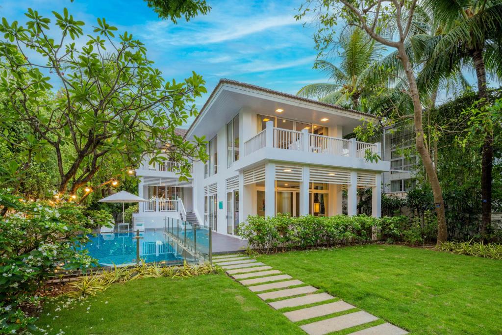 a white house with a swimming pool and a yard at Diamond sea villa in Danang