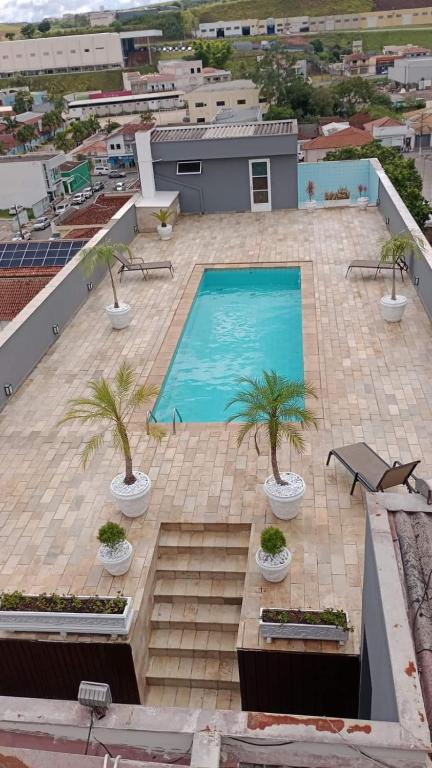 an overhead view of a swimming pool with palm trees on a building at Palace Hotel Jacutinga JS in Jacutinga