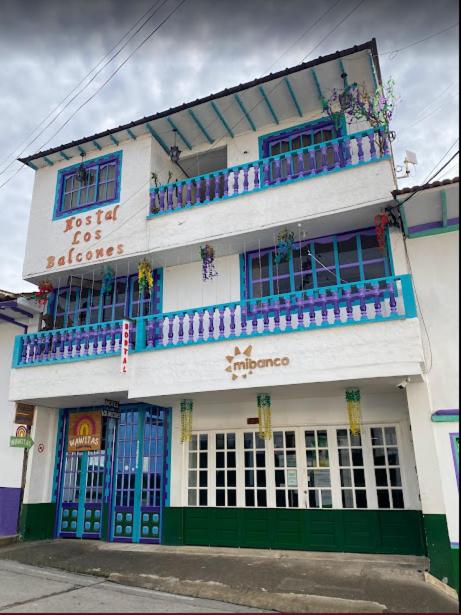 a building with blue and green doors on a street at Hotel Los Balcones in San Agustín