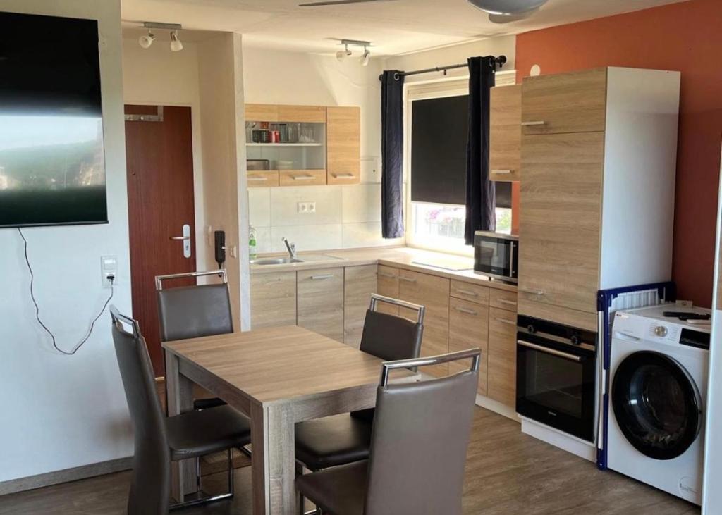 a kitchen with a table and chairs in a kitchen at schönes Apartment mit Festungsblick - FREE Parking - in Würzburg