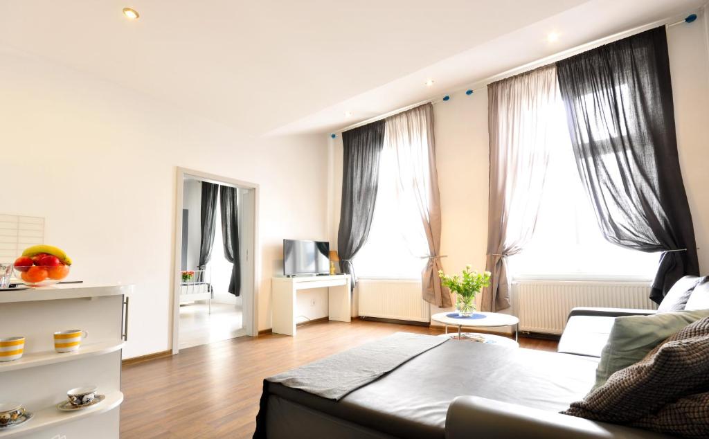 un soggiorno con divano e 2 finestre di Apartamenty Młyńska15 self check-in 24h a Katowice