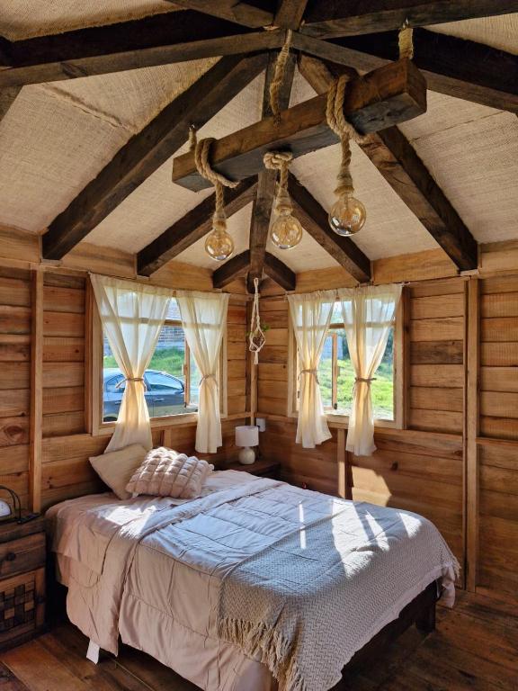 a bedroom with a bed in a room with wooden walls at San Pedro Atmatla Zacatlan Cabins in Zacatlán