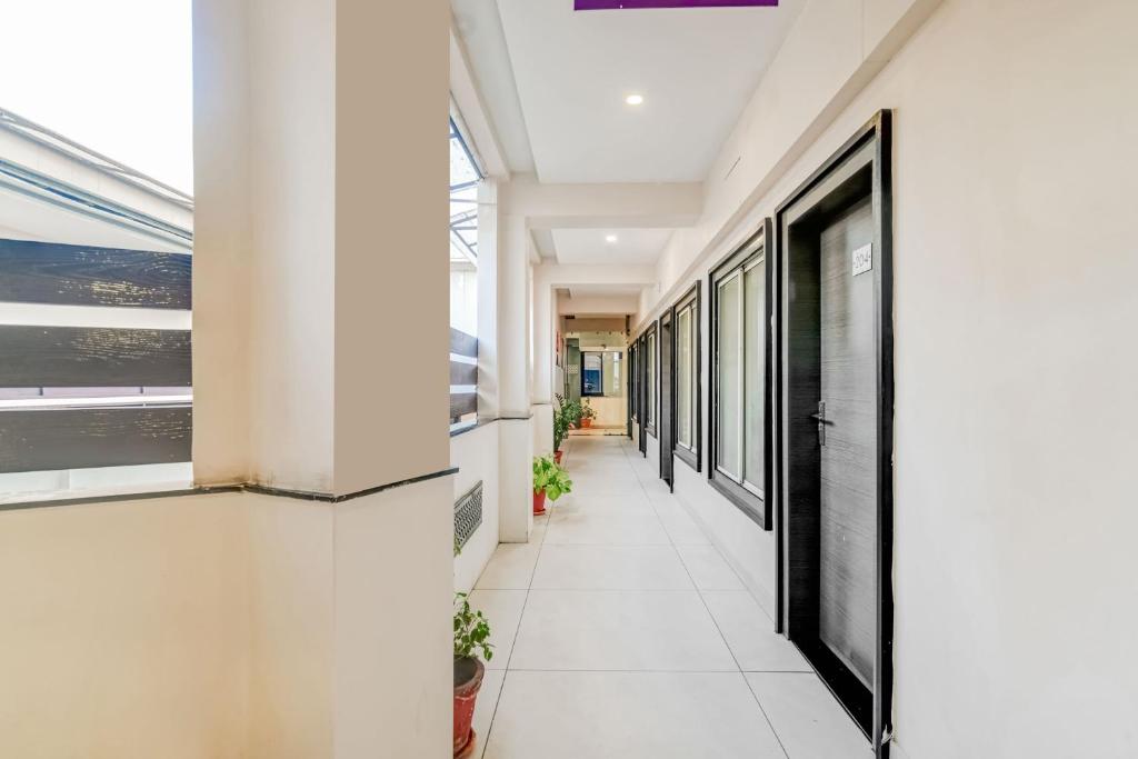 an empty corridor in a building with windows at Super Townhouse Dewas City Formerly Utsav in Dewās