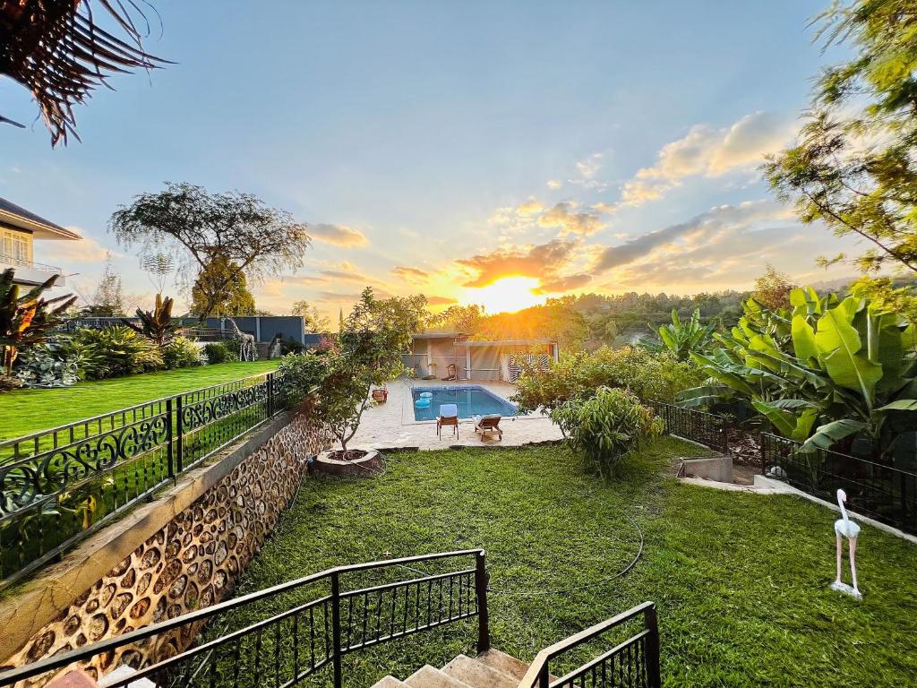 a backyard with a fence and a swimming pool at Stargate Apartments in Arusha