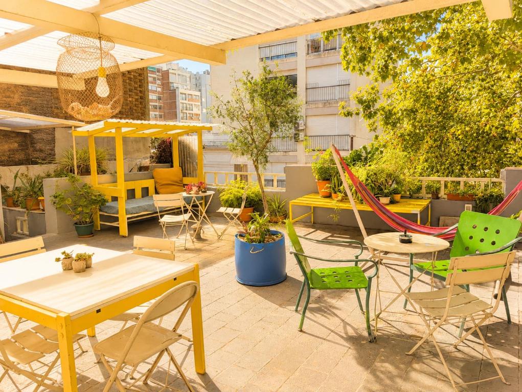 a patio with tables and chairs and a hammock at Youki Haus Hostel in Montevideo