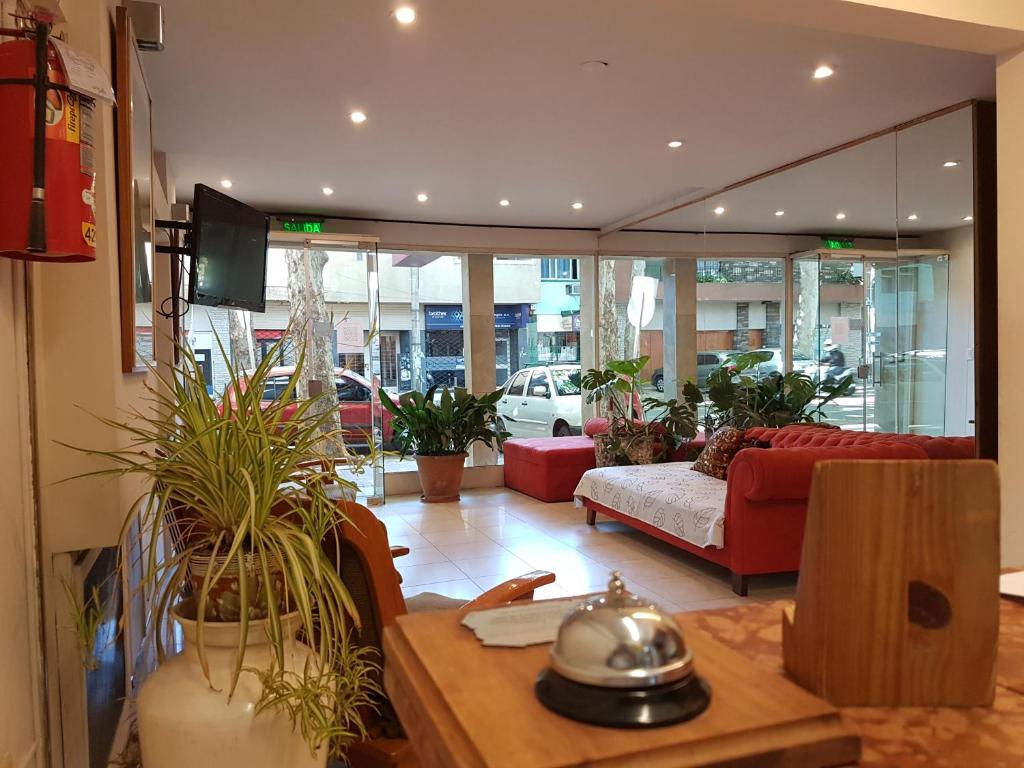 a living room filled with lots of potted plants at Nuevo Castillo Hotel in Mendoza