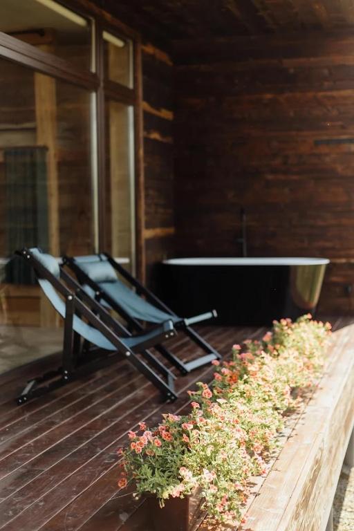a bath tub sitting on top of a deck with flowers at Яблуневий схил in Tukhlya