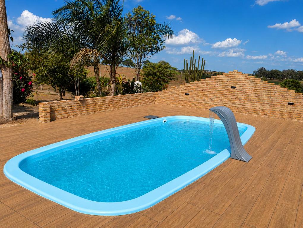a swimming pool with a water fountain on a patio at Chácara Aconchegante com Piscina e Churrasqueira Perto do Ponto Turístico de Bezerros in Bezerros