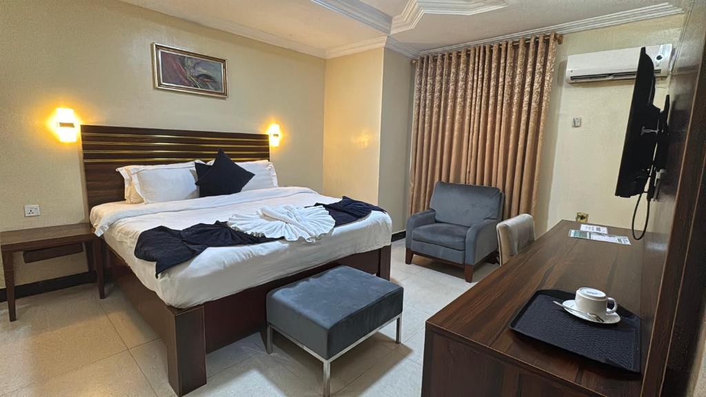 a hotel room with a bed and a chair at The Carlisle Hotel LTD in Asaba