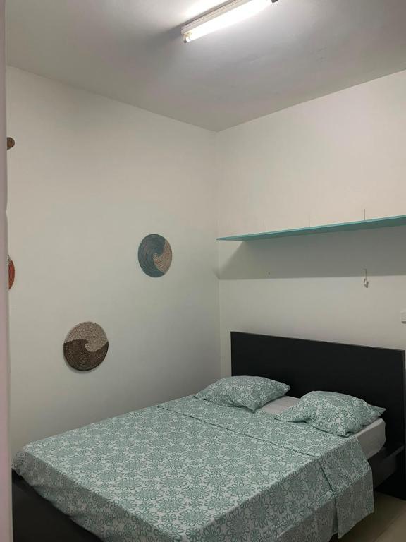 a bedroom with a bed and a white wall at Old house in Tarrafal