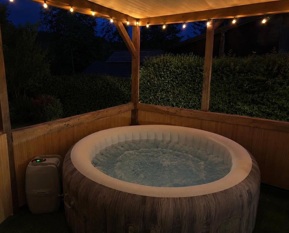 a hot tub in a backyard at night with lights at Mancs&Buborék Kutyabarát Vendégház in Komló