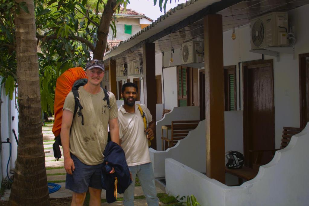 two men are standing outside of a building at Arugambay Wave House in Arugam Bay