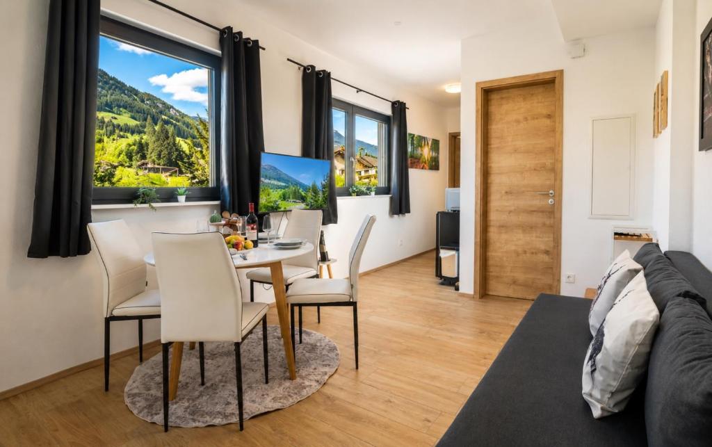 a living room with a table and chairs and a large window at Mountain Chalet Bergblick Top 2 in Fieberbrunn