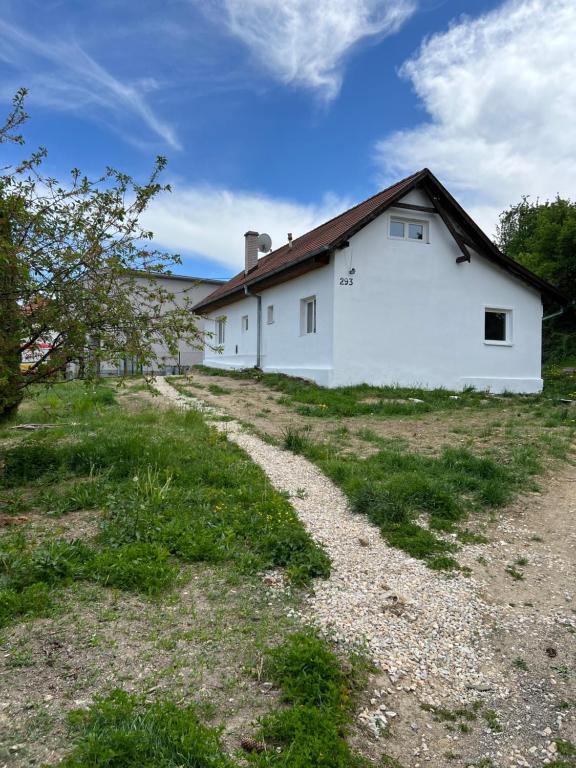 a white house with a gravel road in front of it at Jastrabie House in Trenčianske Jastrabie