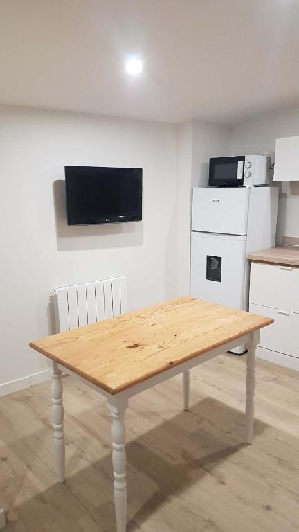 a wooden table in a room with a kitchen at studio in Saint-Georges-de-Luzençon