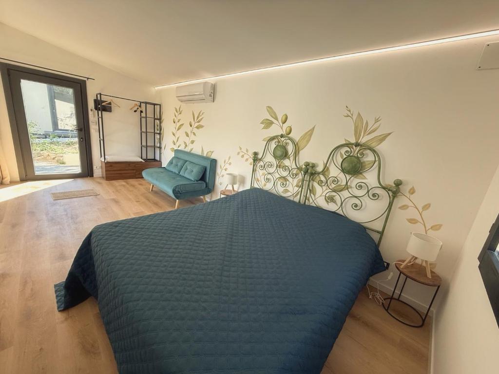 a bedroom with a blue bed and a blue chair at Amici del Colle - Olive Tiny Houses in Borgo a Buggiano
