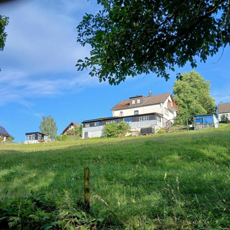 a house on a hill with a field of grass at Sunrise B&B Hellenthal in Hellenthal