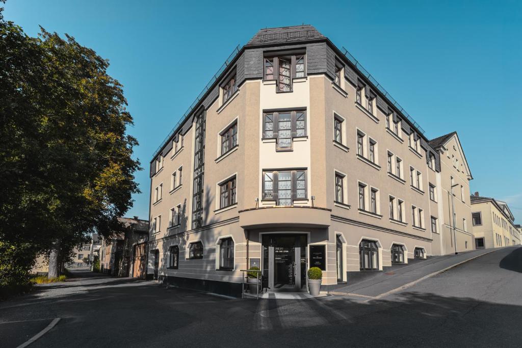 a large white building on a city street at Filet & Freunde in Oelsnitz