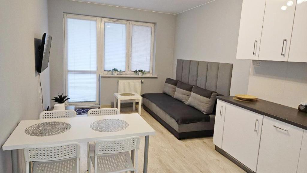a kitchen and living room with a table and a couch at Jedenastka in Płock