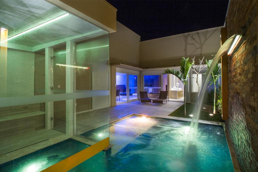 a swimming pool in the middle of a house at Leblon Motel in Barretos