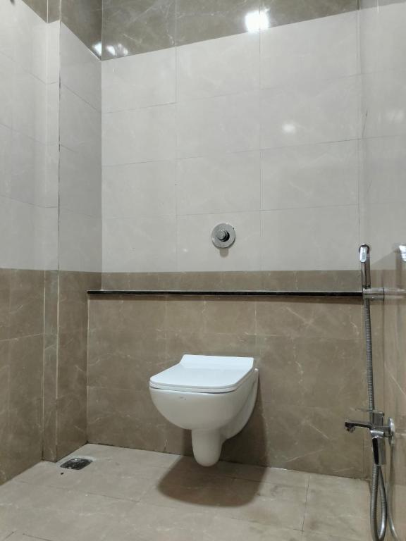 a bathroom with a white toilet in a room at Hotel Atlas in Raigarh