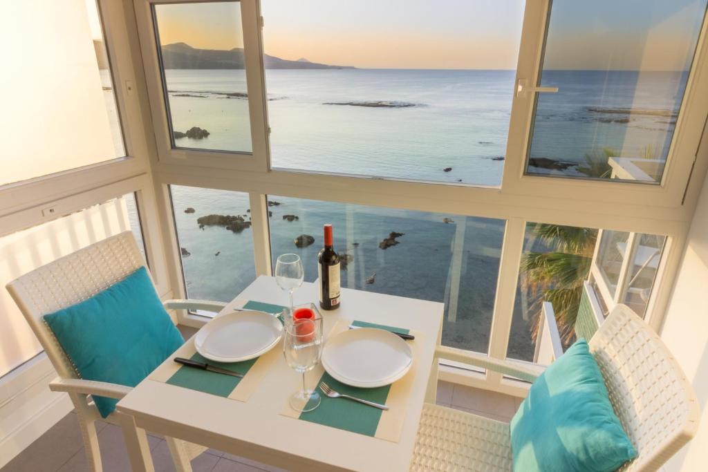- une table avec deux chaises et une table blanche avec des verres à vin dans l'établissement Living Las Canteras Homes - BEACHFRONT LOVE STORY, à Las Palmas de Gran Canaria