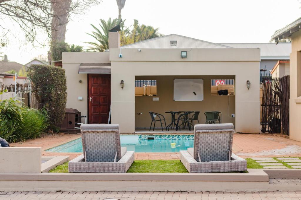 a house with a swimming pool and two chairs at Edenvale corner in Edenvale